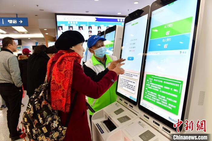患者在指导下使用人脸识别系统预约专家号