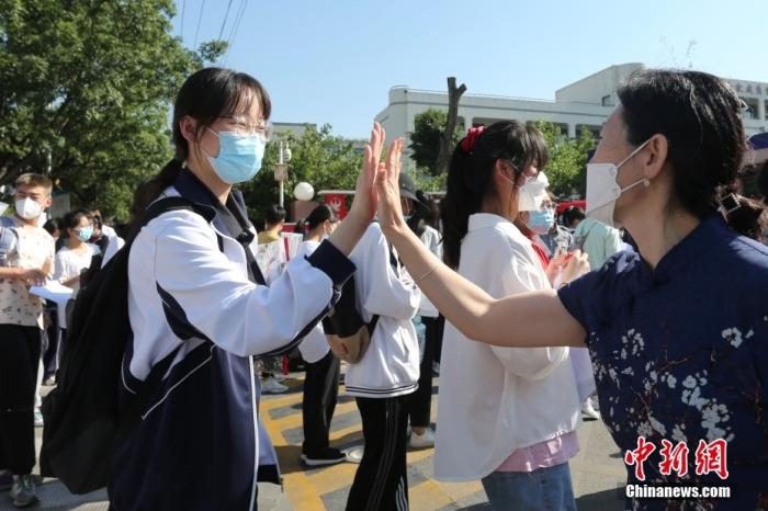 山东泰安二中考点外，带队老师与考生击掌