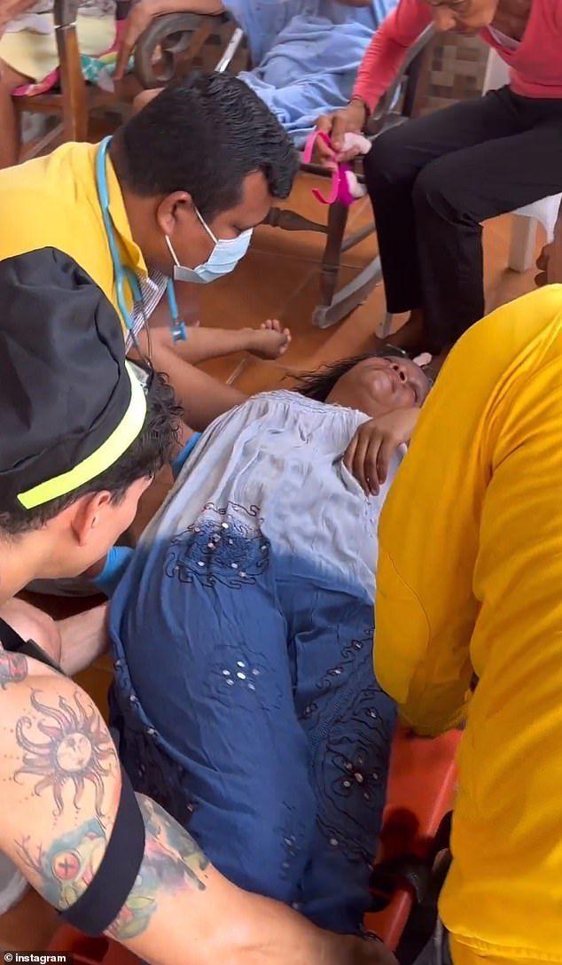 画面中一位老妇被医护人员抬上了担架，准备将其运往医院