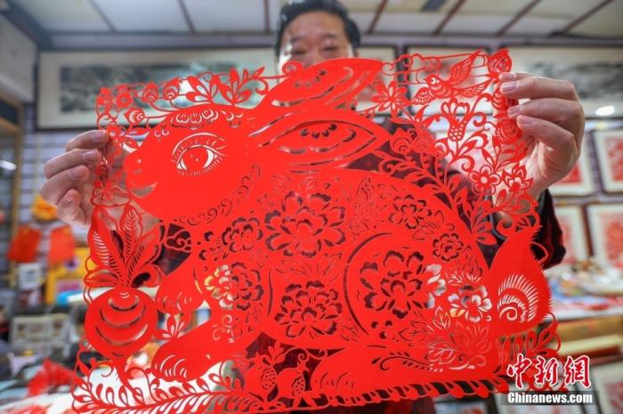 南京市工艺美术大师、非遗剪纸传承人陈耀在其工作室展示他创作的兔年剪纸作品，迎接新春佳节的到来 ...