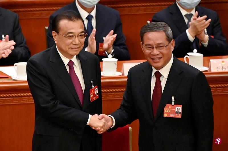 全国人大会议宣布李强（右）出任中国新一任国务院总理后，李强与卸任的李克强握手 ...