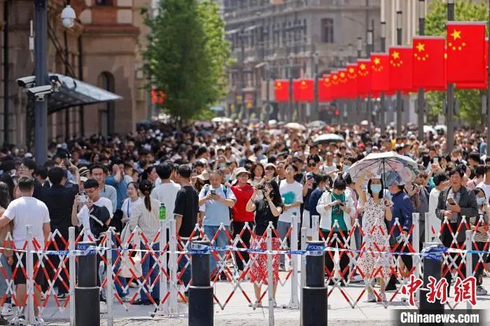 游客在上海南京东路步行街上拍摄城市建筑