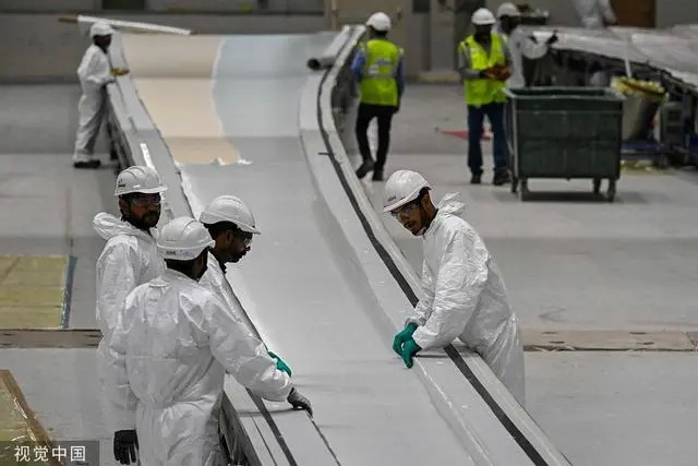 印度阿达尼集团，员工在车间内制造风力发电涡轮机叶片