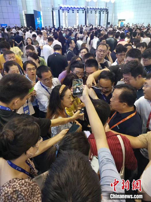 北京智源人工智能研究院理事长、北京大学计算机学院教授黄铁军，被围在人群中 ...