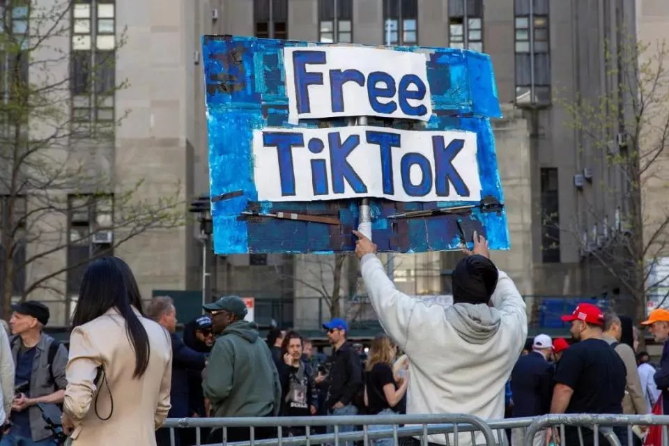 纽约一名男子在特朗普的封口费案审判法院前举着“让TikTok自由”的标志