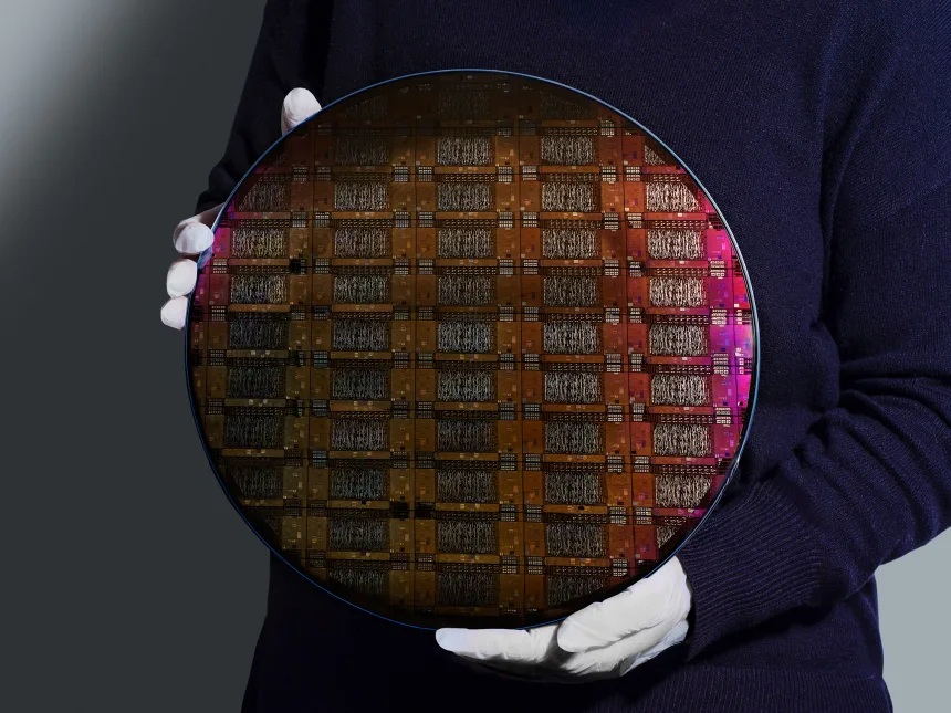 IBM 的一名研究人员拿着晶圆，也就是用于制造处理器和芯片的硅片