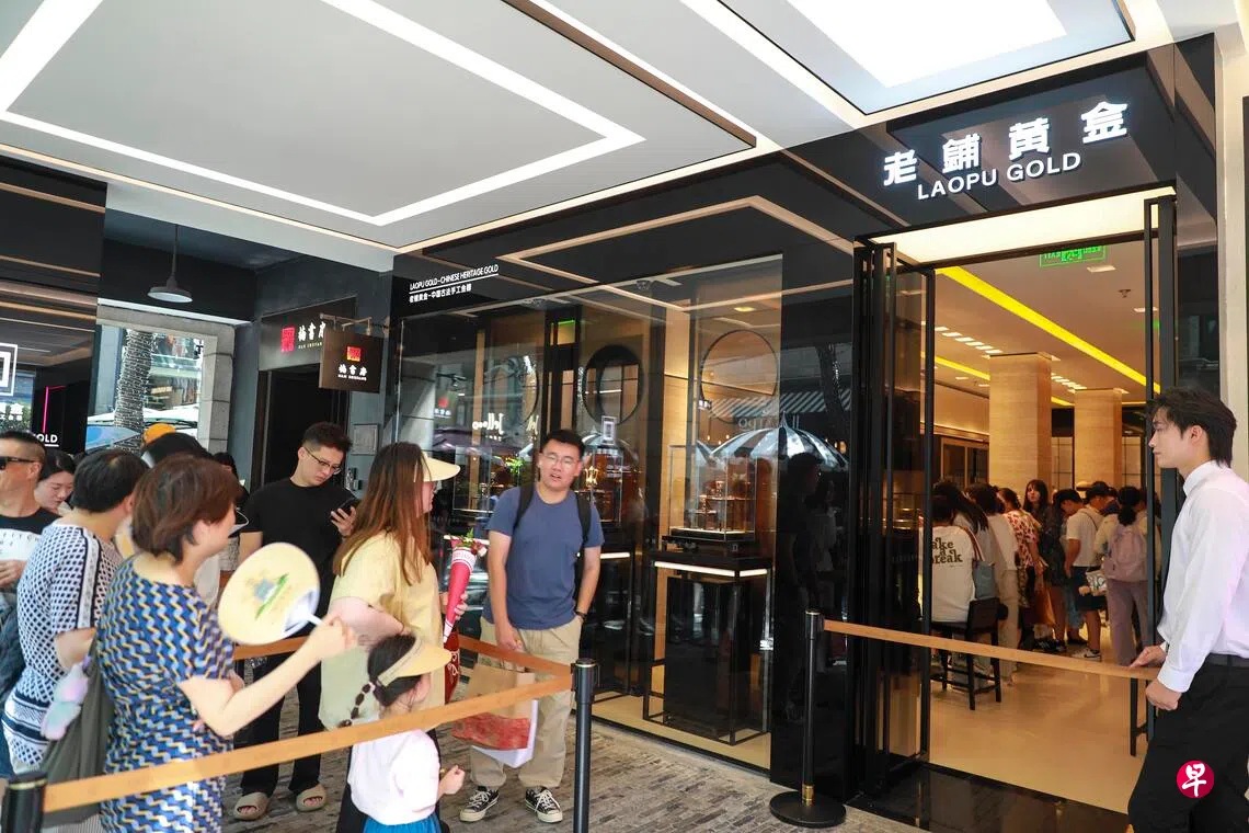 中国消费者8月24日在上海一家老铺黄金门店外排队等候进入